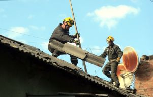 Рятувальники знімають уламки зі зруйнованого даху будинку після масованої російської атаки на Київ