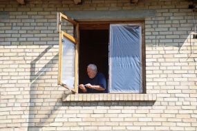 Мужчина ремонтирует выбитое окно