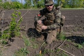 A police officer from the explosives disposal unit of the National Police of Ukraine prepares to detonate a Russian POM-4 anti-personnel mine