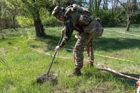 A policeman from the explosives squad of the National Police of Ukraine checks the area for mines and booby traps
