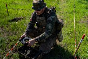 A policeman from the explosives disposal unit of the National Police of Ukraine prepares a discovered TM-62 anti-tank mine for removal