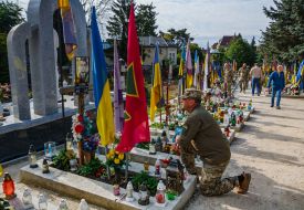 A serviceman honors the memory of his fallen comrades