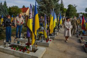 People lay flowers at the graves of soldiers