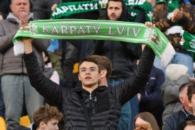 A fan in the stands holds a scarf with the inscription: "Karpaty Lviv"