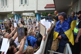 People show photos of missing persons to a prisoner of war who returned to Ukraine