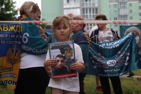 A girl holds a photo of a missing person in her hands