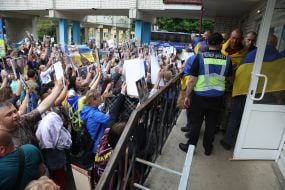 People show photos of missing persons to a prisoner of war who returned to Ukraine