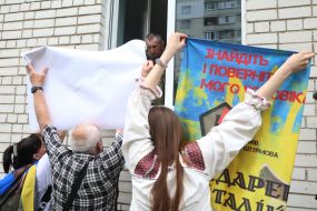 People show photos of missing persons to a prisoner of war who returned to Ukraine