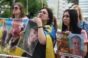 Women hold photos of missing people