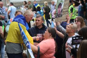 Women show photos of missing persons to a prisoner of war who returned to Ukraine