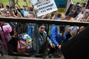 Women hold photos of missing people