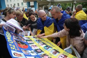 Women show photos of missing prisoners of war who returned to Ukraine
