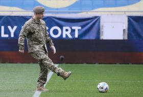 A soldier makes a symbolic kick at the ball