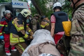 Rescuers carry a person on a stretcher to the ambulance