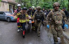 Рятувальники несуть людину на ношах до швидкої допомоги