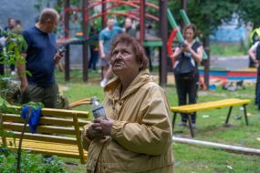 An elderly woman near a house damaged in a massive combined attack on Kharkiv