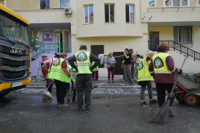 Співробітники комунальної служби біля будинку, що постраждав внаслідок масованої комбінованої атаки на Харків