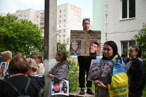 People hold photos of missing people