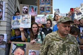 People hold photos of missing people