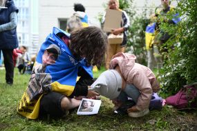 People hold photos of missing people