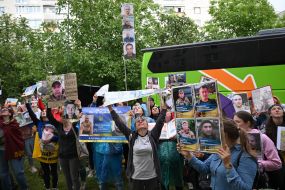 People hold photos of missing people