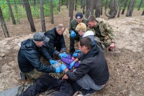 Учасники заняття відпрацьовують надання домедичної допомоги і евакуації пораненого з поля бою в Харківській області