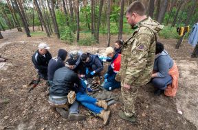 Учасники заняття відпрацьовують надання домедичної допомоги і евакуації пораненого з поля бою в Харківській області