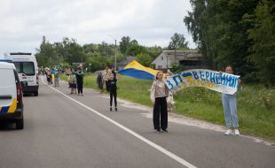 People along the road meet buses with prisoners of war