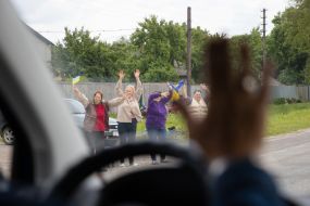 People along the road meet buses with prisoners of war