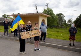 People along the road meet buses with prisoners of war