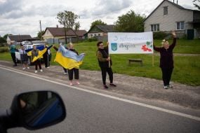 People along the road meet buses with prisoners of war