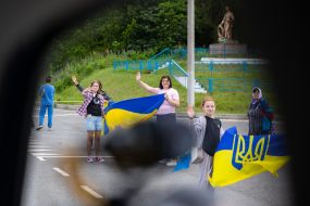 People along the road meet buses with prisoners of war