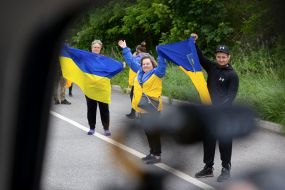 People along the road meet buses with prisoners of war