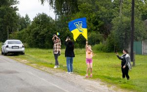People along the road meet buses with prisoners of war