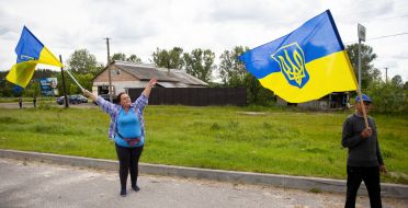 People along the road meet buses with prisoners of war