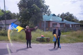 People along the road meet buses with prisoners of war