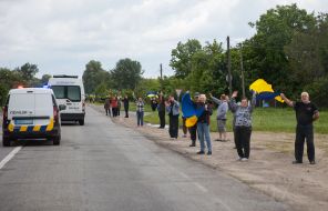 People along the road meet buses with prisoners of war