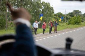 People along the road meet buses with prisoners of war