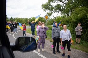 People along the road meet buses with prisoners of war