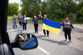 People along the road meet buses with prisoners of war