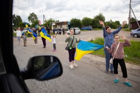 People along the road meet buses with prisoners of war