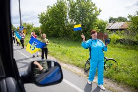 People along the road meet buses with prisoners of war