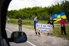 People along the road meet buses with prisoners of war