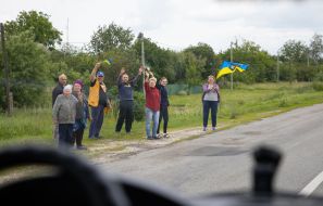 People along the road meet buses with prisoners of war