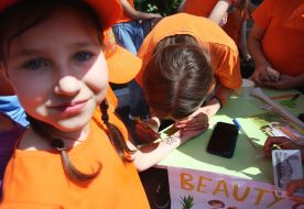 A girl gets a pattern painted on her hand