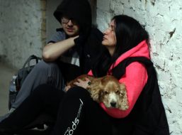 Woman with a small dog in her armshides in a shelter of the dormitory of NAU (now Kyiv Aviation Institute) in Kyiv