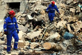 Спасатели с поисковой собакой на развалинах разрушенного в результате прямого попадания ракеты подъезда в жилом доме в Соломенском районе в Киеве