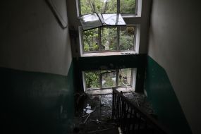 Shattered windows in the entrance of a residential building after a massive attack in the Solomianskyi district of Kyiv