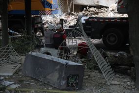 Спасатели сели отдохнуть на стиральной машинке возле жилого дома, в который попала ракета, в Соломенском районе в Киеве