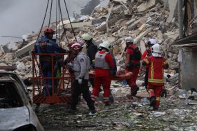 Спасатели и медики работают на месте прямого попадания ракеты в жилой дом в Соломенском районе в Киеве